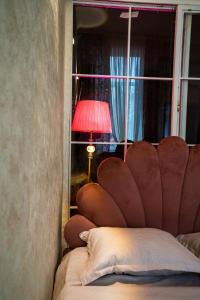 a bedroom with a bed with a lamp and a window at კოსტავას 8 in Tbilisi City