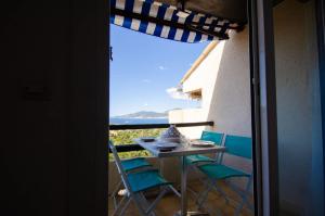 a table and chairs on a balcony with a view at Duplex 2 chambres, vue mer & balcon - 6 couchages in Porticcio
