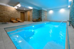 a swimming pool in a house with blue lighting at Berg Liptov in Liptovský Mikuláš