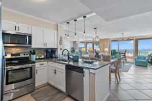 a kitchen with white cabinets and stainless steel appliances at Magnolia House 504 At Destin Pointe Resort in Destin