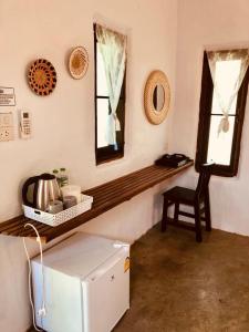 Zimmer mit einem Kühlschrank, einem Spiegel und einem Stuhl in der Unterkunft Pai casita resort ,Mud house -5mins from city in Kampong Huaibū