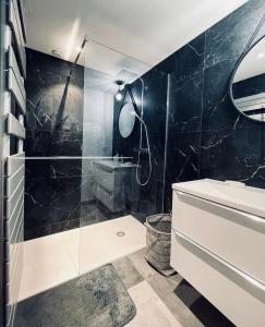 a bathroom with a glass shower and a sink at Sous les pins in Sanary-sur-Mer