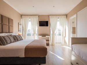 リスボンにあるヴィラ ガーデン ゲストハウスのベッドルーム1室(ベッド2台、薄型テレビ付)