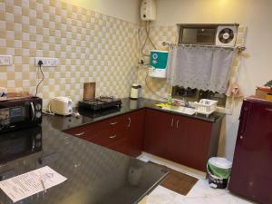 a kitchen with a counter and a microwave on the wall at Family Friendly Studio Apartment -2 in Bengaluru
