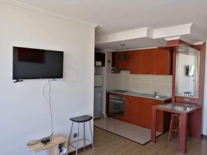 a kitchen with a flat screen tv on a wall at Céntrico Dpto Calama in Calama