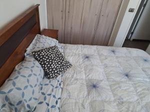 a bed with a pillow on it in a bedroom at Céntrico Dpto Calama in Calama
