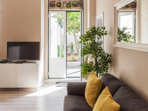 a living room with a couch and a tv at Vila Garden Guesthouse in Lisbon
