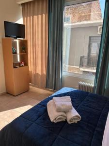 a bedroom with a blue bed with a towel on it at Alpha apartment H1 in Serres