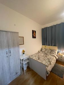 a small bedroom with a bed and a desk at Orchid International in Abu Dhabi