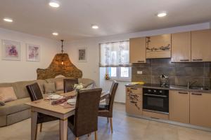 a kitchen and living room with a table and a kitchen and a couch at Villa Jordan, a charming Villa near the sea, with garden & pool in Nedeščina