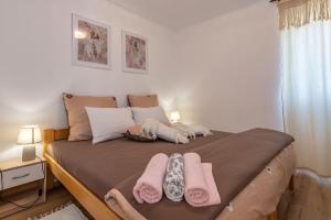 a bedroom with a bed with pink towels on it at Villa Jordan, a charming Villa near the sea, with garden & pool in Nedeščina +23 photos