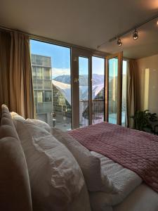 - une chambre avec un lit et une vue sur les montagnes dans l'établissement City Center Apartment, à Tromsø