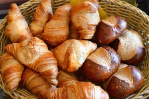 a basket filled with croissants and breads at Hotel Weinhaus Hoff in Bad Honnef am Rhein