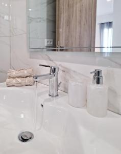 a white bathroom sink with two glasses on it at Coastal Ierapetra 2 in Ierapetra +35 photos
