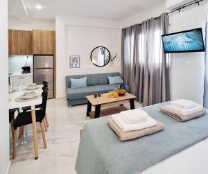 a living room with a blue couch and a table at Coastal Ierapetra 2 in Ierapetra