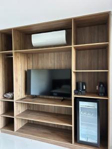 a entertainment center with a flat screen tv at Maluhia Ilhabela 5 in Ilhabela