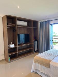 a bedroom with a bed and a tv in a room at Maluhia Ilhabela 5 in Ilhabela