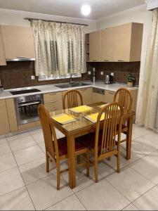 a kitchen with a wooden table and chairs in it at TranquilityHouse in Tríkala