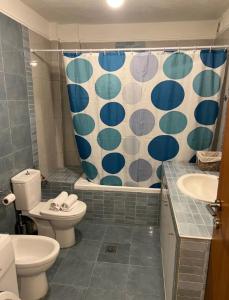a bathroom with a toilet and a shower curtain at TranquilityHouse in Tríkala