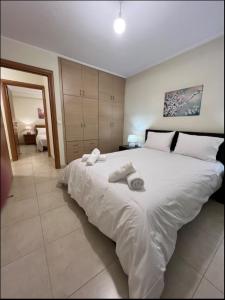 a bedroom with a large white bed with towels on it at TranquilityHouse in Tríkala