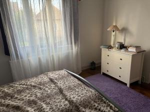 a bedroom with a bed and a dresser with a window at Village house & Micro Winery in Sîntioana de Mureş