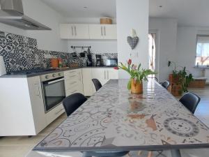 a kitchen with a table with a vase of flowers on it at le refuge du bonheur in Bitche
