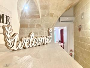 a sign that reads wine adventure sitting on a bed at Antica Pietra in Polignano a Mare