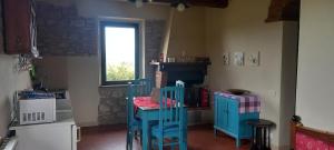 a kitchen with two blue chairs and a window at 2 girasoli primo piano in Sanfatucchio