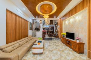 a living room with a large couch and a television at Green House in Danang