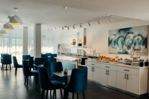 a kitchen with blue chairs and a dining room at MIA Urban Fès in Fez