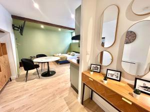 a room with a table and two mirrors on the wall at Le Verdoré, au pied du centre historique in Bourg-lès-Valence