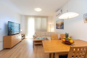 a living room with a dining room table and a television at Boki 2 one bedroom apartment in old town with balcony in Zadar