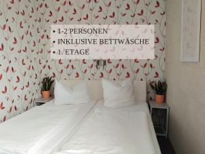 a bedroom with a bed with a sign on the wall at Haus Krabbe Apartments, zentral gelegen zwischen Bremerhaven und Cuxhaven, Hunde kostenfrei willkommen, hauseigene kostenfreie Parkplätze, Unterstellmöglichkeit für Fahrräder und E-Bikes in Wremen