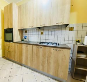 Una cocina con gabinetes de madera y un fregadero. en Casa Via Dante, en San Cataldo