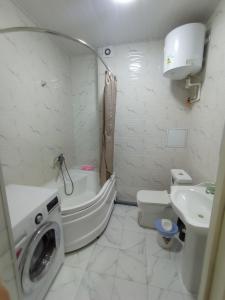 un bagno con lavatrice accanto a servizi igienici di 32 микрорайон 60а a Khujand