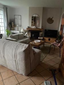 a living room with a couch and a table at Villa Buff-ô-T'iu - 3 chambres in Courgeac