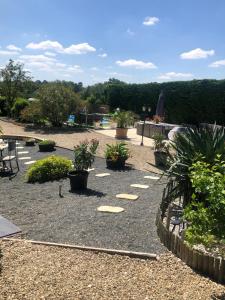 a garden with potted plants on the ground at Villa Buff-ô-T'iu - 3 chambres in Courgeac