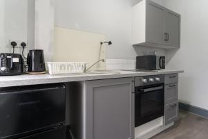 a kitchen with a counter with a sink and a dishwasher at Luxury Moseley Studio - 8 in Birmingham