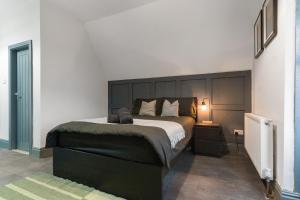 a bedroom with a large bed with a black headboard at Luxury Moseley Studio - 8 in Birmingham +2 photos