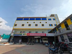 韦洛尔SAlBALA LODGE - AC ROOMS WITH COOKING FACILITIES Near CMC的一座大楼，前面停着摩托车