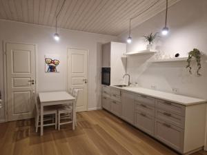 a kitchen with white cabinets and a sink and a table at Taadi studio apartment in Loosu