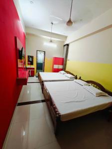 韦洛尔SAlBALA LODGE - AC ROOMS WITH COOKING FACILITIES Near CMC的红色和黄色墙壁的客房内的两张床