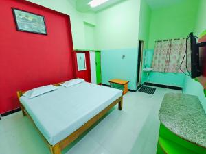 韦洛尔SAlBALA LODGE - AC ROOMS WITH COOKING FACILITIES Near CMC的一间卧室设有一张床和红色的墙壁