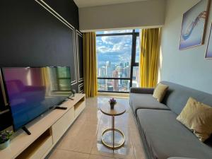 a living room with a couch and a large television at Luxury Axon Suites KLCC in Kuala Lumpur