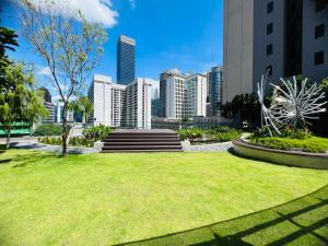 a park with green grass and buildings in the background at Luxury Axon Suites KLCC in Kuala Lumpur