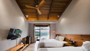 a bedroom with two beds and a ceiling fan at Yingde YeDuGu Resort in Gaozhoupu