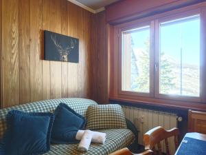 a living room with a couch and a window at Hostdomus - Good Vibes Apartment in Sestriere