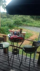 a table and chairs on a deck with food on it at Casa bellavista in Resende