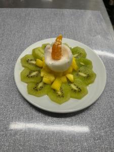a plate of kiwi and fruit with a dessert on it at Le Mas des Collines in Tourtour