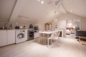 a kitchen and dining room with a table and washing machines at GreeneStay Sindang DDP Seoul in Seoul